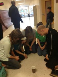 Students and Huddle leaders pray before class as part of the Daniel Challenge to pray in school three times a day.