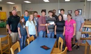 vilonia-family-2-300x179 Smackover HS Huddle leaders presented a check to the Clark family. Front Row (L to R): Katherine Jerry, Kayla Green, Logan Clark, Bryan & Jacob Clark (VHS students) along with their mom Back Row (L to R): Coach David Preston, Jackson Martin, Cooper Thurmon, Joseph Clark, Tripp Evans, Coach Mikey Moss